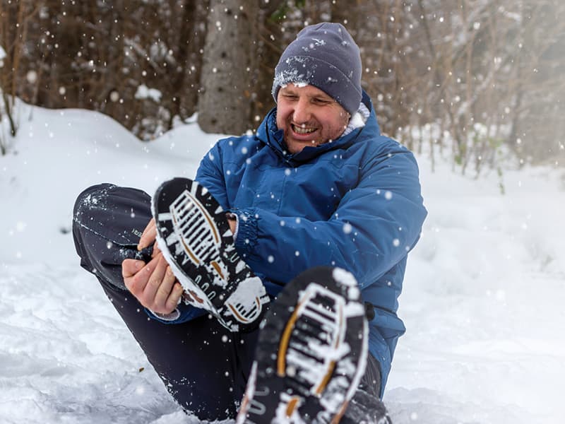 Man in snow with injured ankle