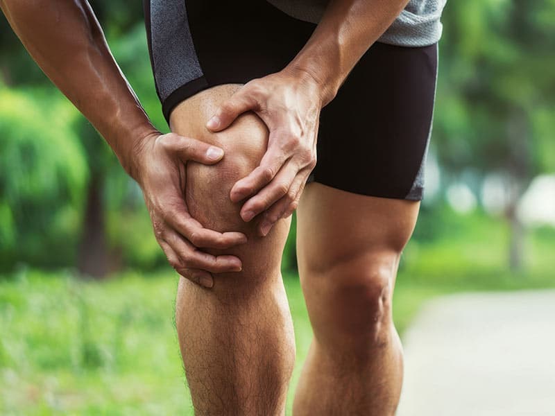 athletic man holding painful knee