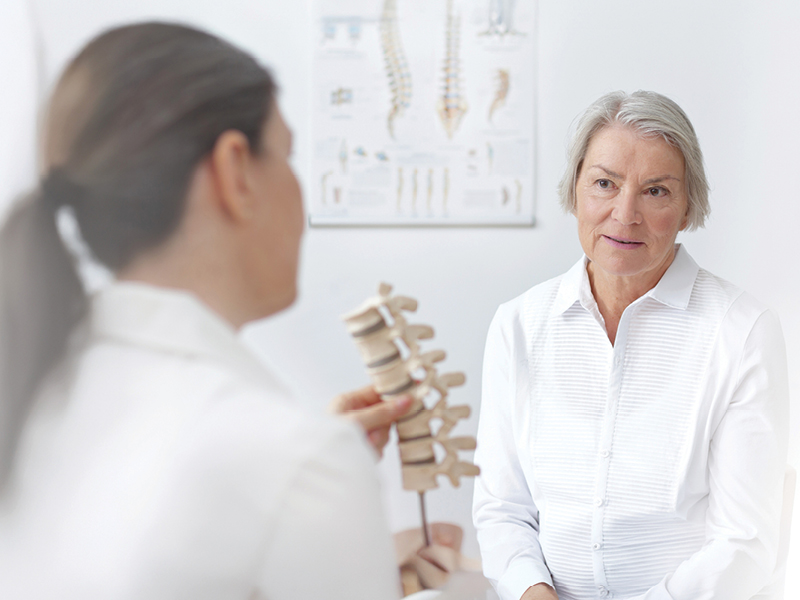 mature woman talking to spine doctor