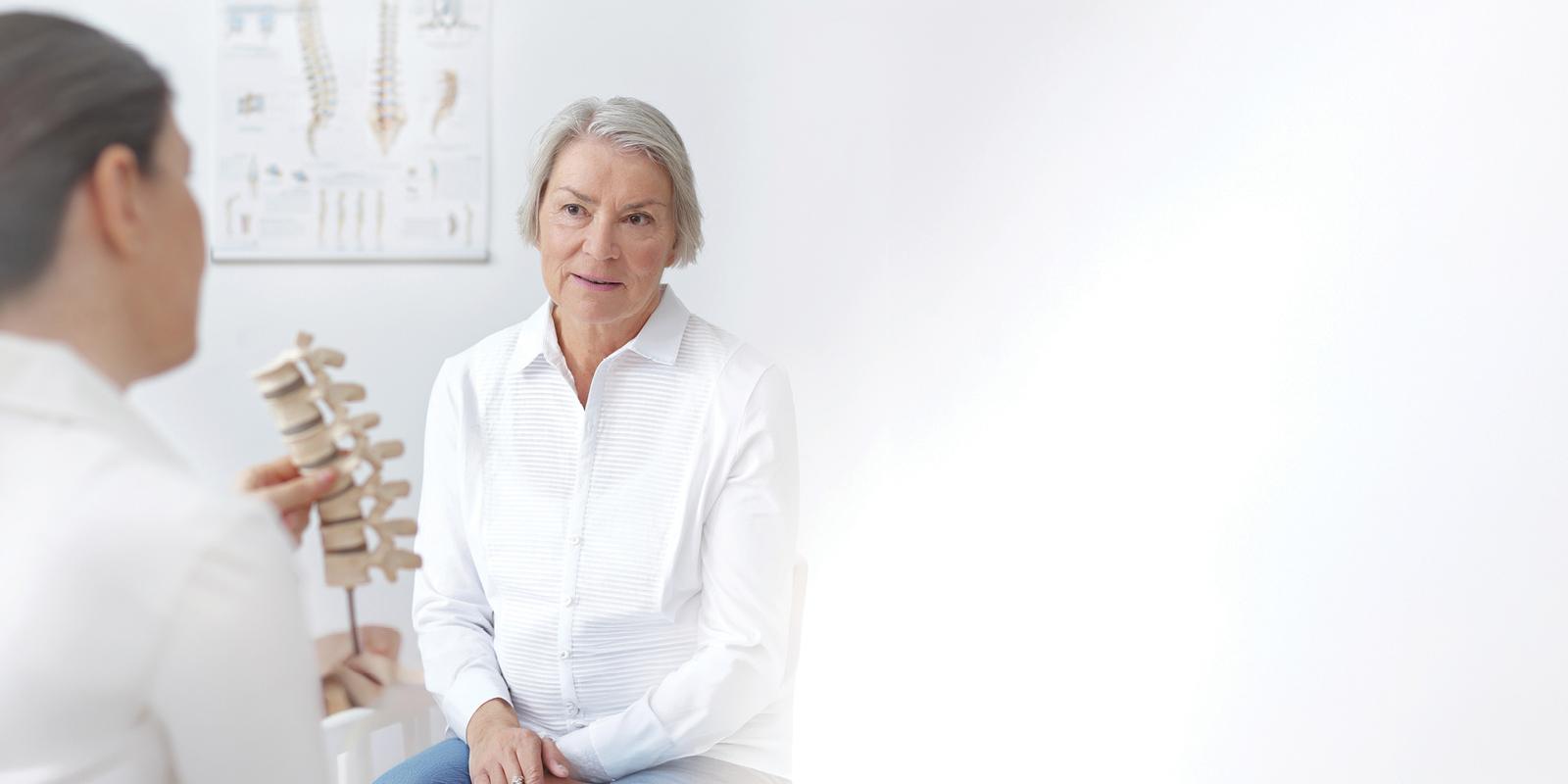 mature woman talking to spine doctor