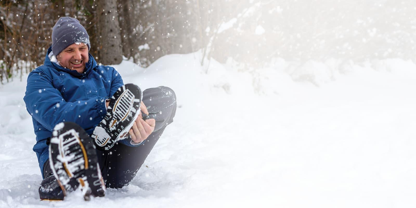 Man in snow with injured ankle