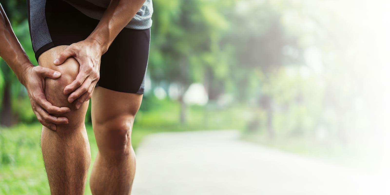 athletic man holding painful knee